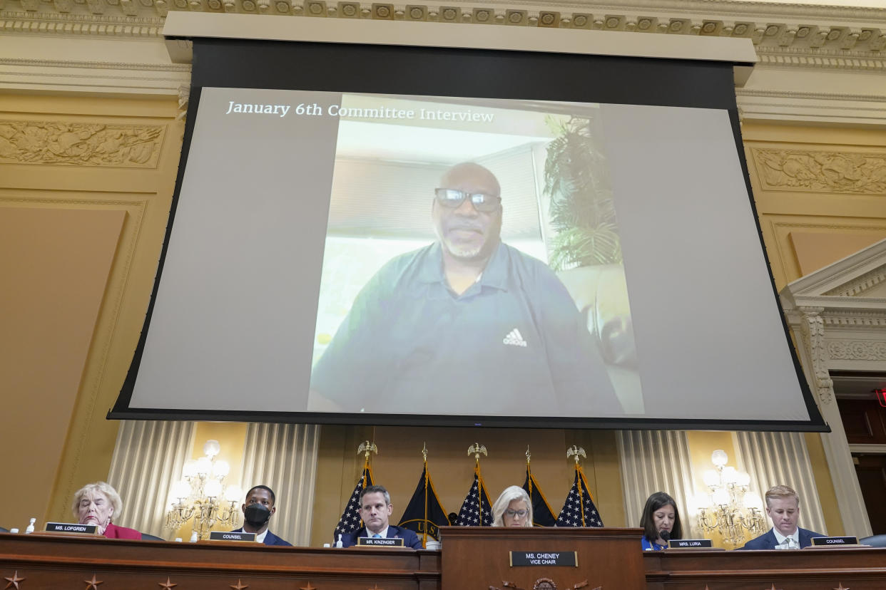 A video screen above the seated members of the House select committee shows retired Washington Metropolitan Police Department Sgt. Mark Robinson under the words: January 6th Committee Interview