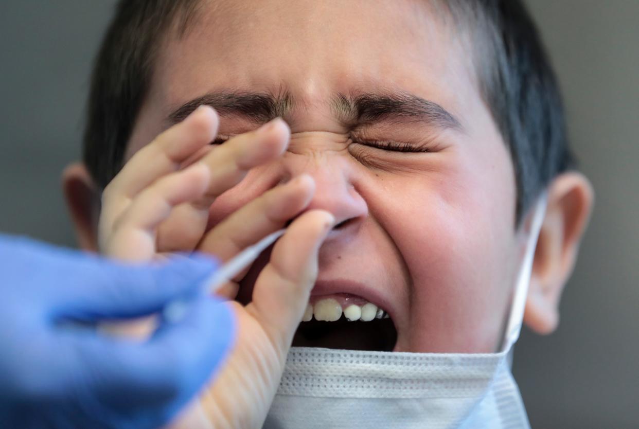 Mason Isiordia, 7, grimaces as phlebotomist Lisa Gray administers a nasopharyngeal swab to test for COVID-19 at Salem Health Laboratory in Salem on July 12.