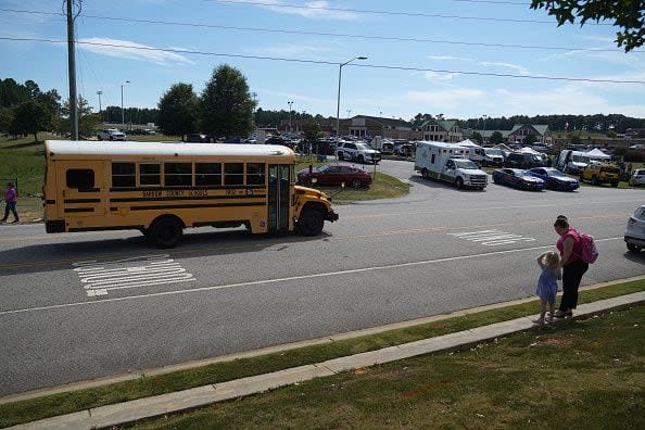 WINDER, GEORGIA - SEPTEMBER 4: A mother and daughter watch as an ambulance leaves after a shooting at Apalachee High School on September 4, 2024 in Winder, Georgia. Multiple fatalities and injuries have been reported and a suspect is in custody according to authorities.(Photo by Megan Varner/Getty Images)