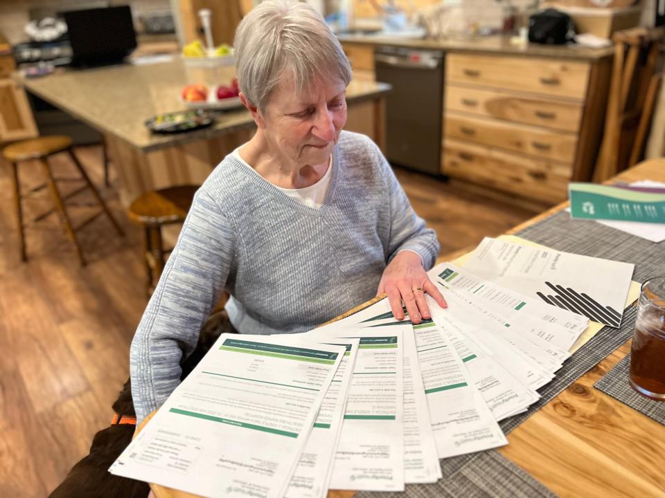 Pat Kreple, 76,of  Stanwood, near Big Rapids, sits with a pile of bills.