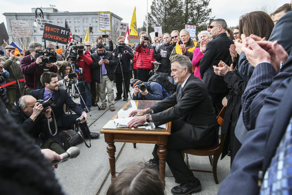 FILE - In this April 11, 2018 file photo, Vermont Gov. Phil Scott finishes signing a gun restrictions bill on the steps of the Statehouse in Montpelier, Vt. Scott faces a challenge by Springfield businessman Keith Stern in the Aug. 14, 2018, Republican primary. (AP Photo/Cheryl Senter, File)