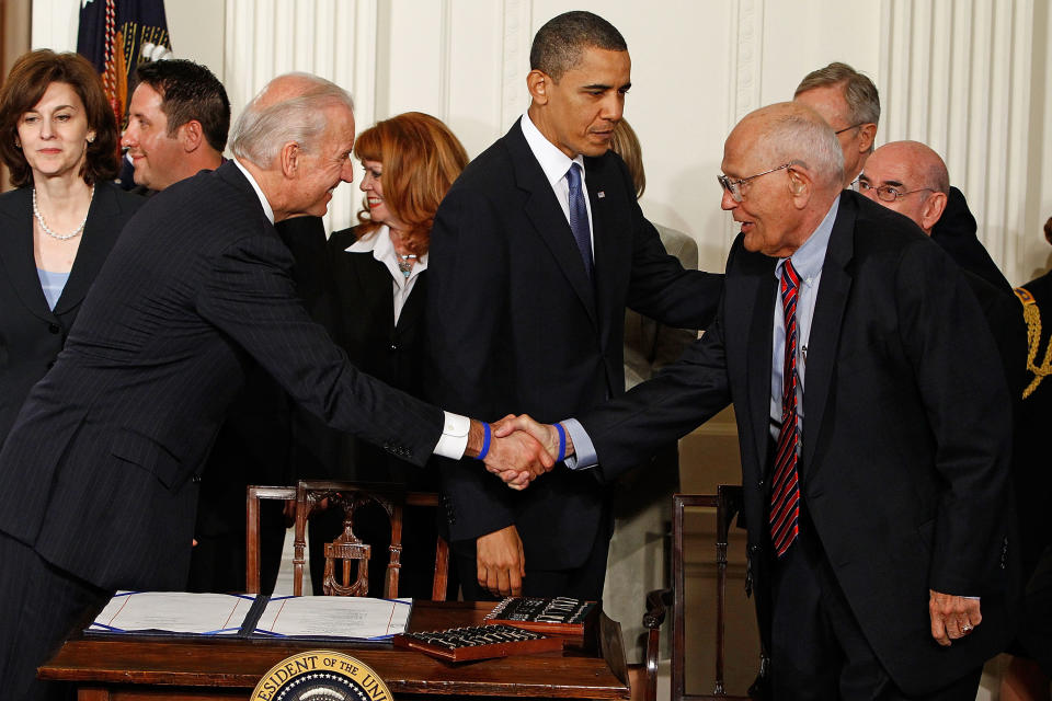 Vice President Joe Biden shakes hands with Dingell before President Barack Obama signs the Affordable Care Act during a ceremony with fellow Democrats in the East Room of the White House on March 23, 2010.