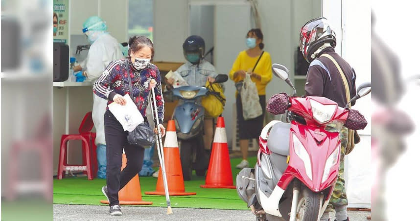 新冠肺炎本土疫情急遽升溫，確診人數攀升，為有效分流醫療量能，台北市政府與台北榮民總醫院合作在自由廣場設置防疫急門診，提供車來速PCR篩檢、看診、給藥「三合一」服務，19日一位民眾拄著枴杖前往排隊篩檢。。（圖／陳俊吉攝）