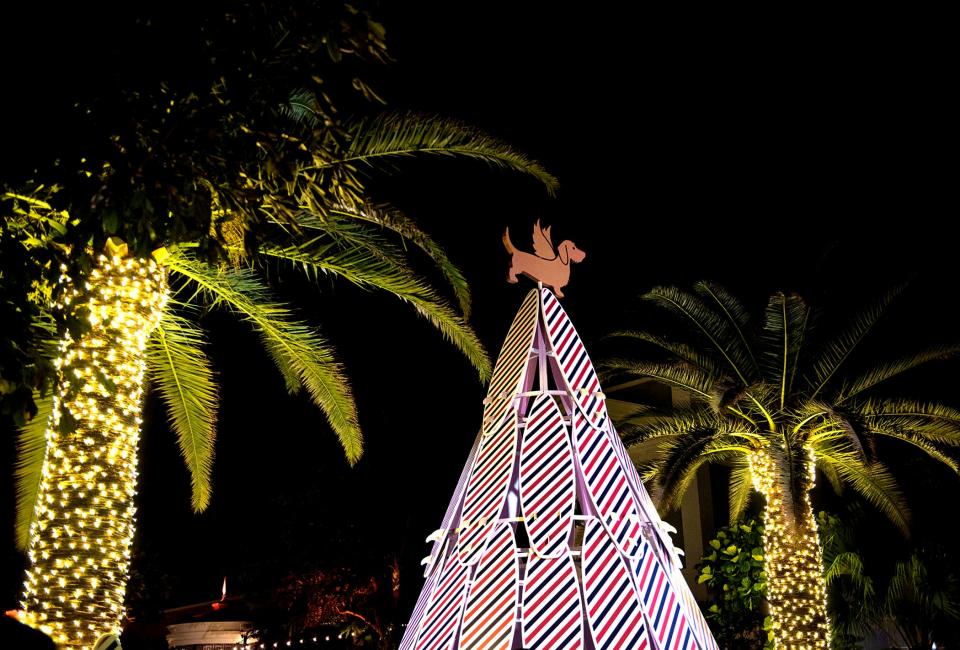 Hundreds attend the Royal Poinciana Plaza holiday surfboard tree, a collaboration with designer Thom Browne, at the reveal party November 30, 2023 in Palm Beach. The tree is the brand's signature red, white, and blue stripes, and the top is Browne's dog Hector.