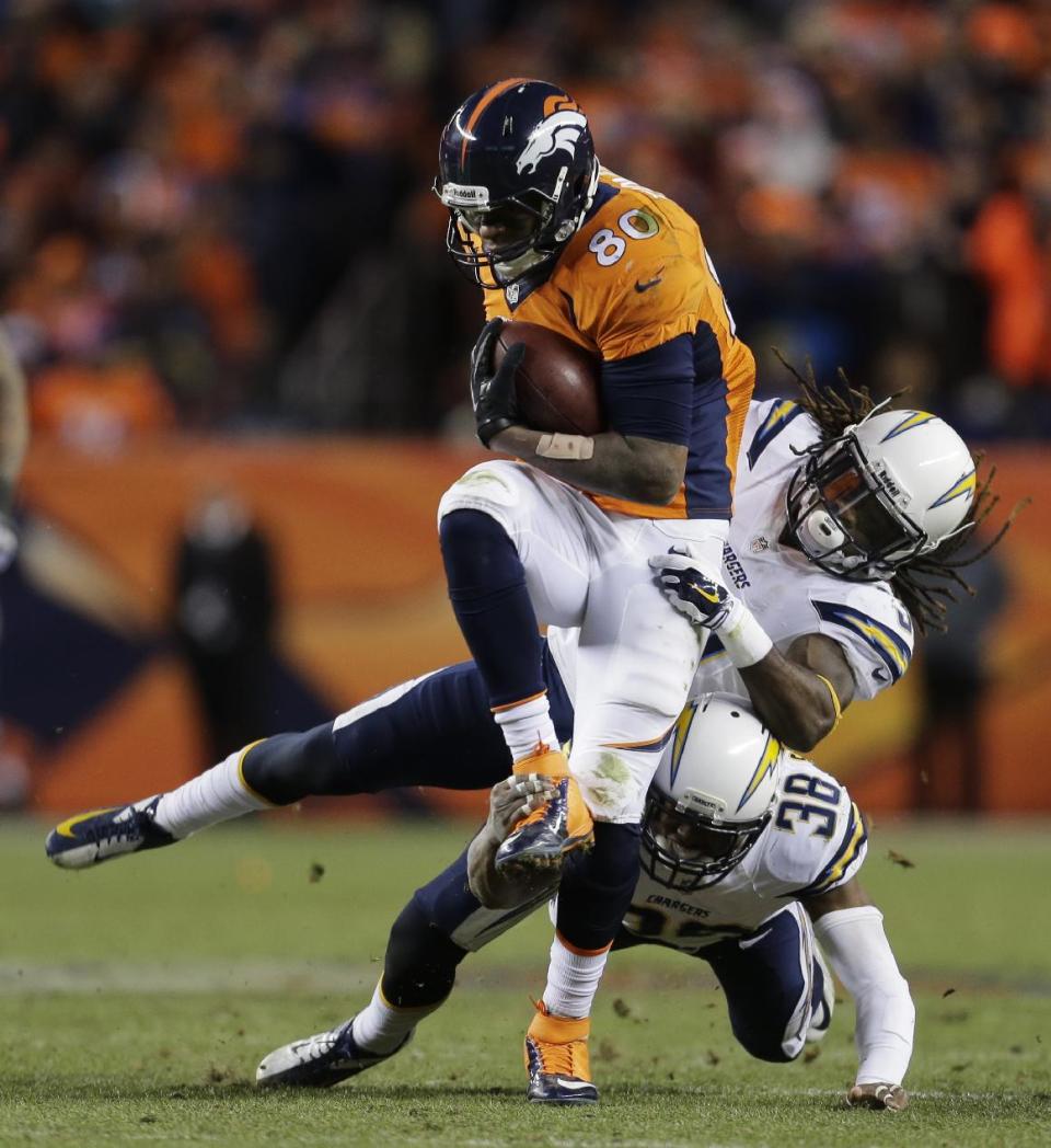 Denver Broncos tight end Julius Thomas (80) is pulled down by San Diego Chargers defensive back Jahleel Addae (37) and San Diego Chargers strong safety Marcus Gilchrist (38) in the fourth quarter of an NFL AFC division playoff football game, Sunday, Jan. 12, 2014, in Denver. (AP Photo/Joe Mahoney)