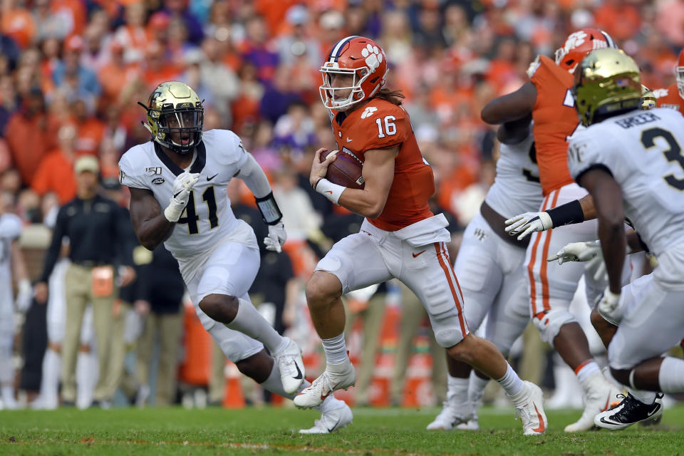 Clemson quarterback Trevor Lawrence (16) scrambles out of the pocket while defended by Wake Forest's Ja'Corey Johns (41) Clemson's during the first half of an NCAA college football game Saturday, Nov. 16, 2019, in Clemson, S.C. (AP Photo/Richard Shiro)