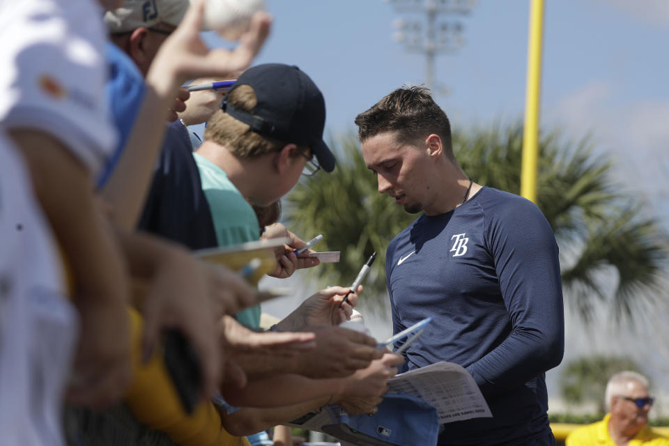 Tampa Bay Rays starting pitcher Blake Snell (4) signs autographs for fans during spring training baseball camp Monday, Feb. 17, 2020, in Port Charlotte, Fla. (AP Photo/John Bazemore)