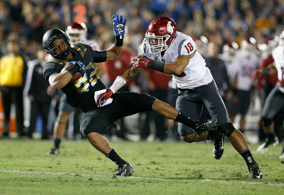 PASADENA, CA - NOVEMBER 14: Eldridge Massington (82) of the UCLA Bruins catches a pass as Shalom Luani (18) of the Washington State Cougars defends during the second quarter of a game at Rose Bowl on November 14, 2015 in Pasadena, California. (Photo by Sean M. Haffey/Getty Images)