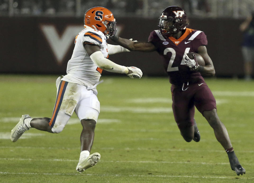 Syracuse defender Marlowe Wax (2) attempts to tackle Virginia Tech running back Malachi Thomas (24) during the second half of an NCAA college football game Thursday, Oct. 26, 2023, in Blacksburg, Va. (Matt Gentry/The Roanoke Times via AP)