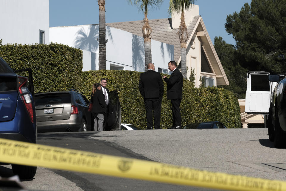 Police investigators stand in a street near a house where three people were killed and four others wounded in a shooing at a short-term rental home in an upscale Los Angeles neighborhood on Saturday Jan. 28, 2023. (AP Photo/Richard Vogel)