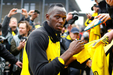 Soccer Football - Usain Bolt participates in a training session with Borussia Dortmund - Strobelallee Training Centre, Dortmund, Germany - March 23, 2018 Usain Bolt signs autographs for fans after Borussia Dortmund training REUTERS/Thilo Schmuelgen