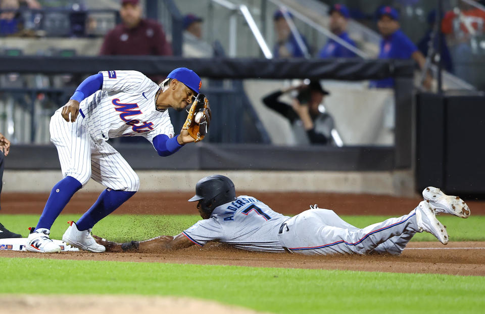 Miami Marlins' Tim Anderson (7) beats the tag of New York Mets' Francisco Lindor during the fifth inning of a baseball game, Tuesday, June 11, 2024, in New York. (AP Photo/Noah K. Murray)