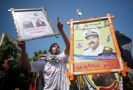 Demonstrators hold pictures of jailed Palestinians during a rally in support of Palestinian prisoners on hunger strike in Israeli jails, in Gaza City April 17, 2017. REUTERS/Mohammed Salem