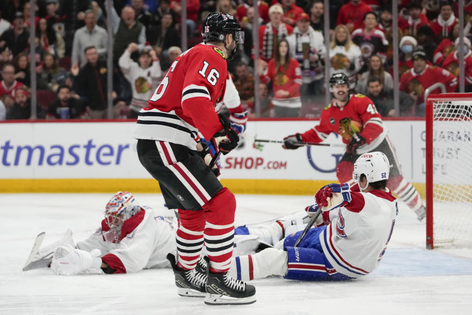 Chicago Blackhawks center Jason Dickinson, front, scores on Montreal Canadiens goaltender Cayden Primeau during the second period of an NHL hockey game Friday, Dec. 22, 2023, in Chicago. (AP Photo/Erin Hooley)