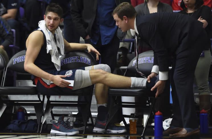 Photo by the AP: Freshman Killian Tillie sits on the bench getting his ankle attended to after falling during Gonzaga's game against the Pilots. Tillie did not return to the game. 