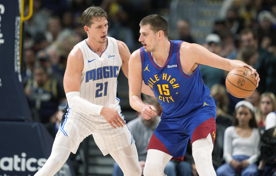 Denver Nuggets center Nikola Jokic, right, drives to the basket as Orlando Magic center Moritz Wagner, left, defends in the first half of an NBA basketball game Friday, Jan. 5, 2024, in Denver. (AP Photo/David Zalubowski)