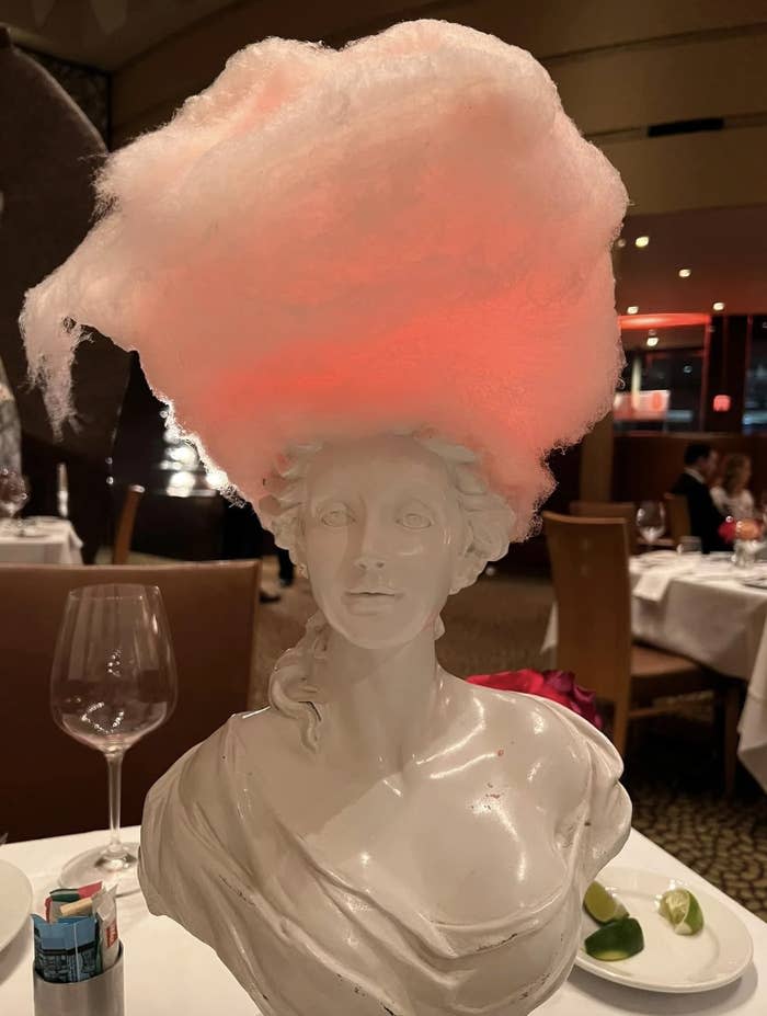 Sculpted bust with a large, illuminated cotton candy hairpiece, set on a restaurant table