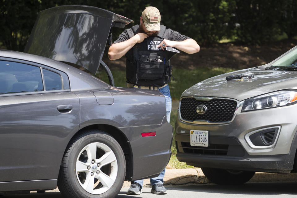 An ATF special agent readies his gear near the building that houses Gannett and USA Today, Wednesday, Aug. 7, 2019, in McLean, Va. (AP Photo/Alex Brandon)