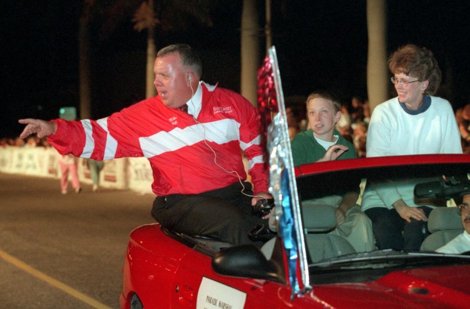 Mike Gill (left) waves at the crowd during the 1998 Edison Festival of Light Grand Parade. Gill has retired as parade chairman after leading the parade for more than four decades. He's been named the 2024 parade's grand marshal.