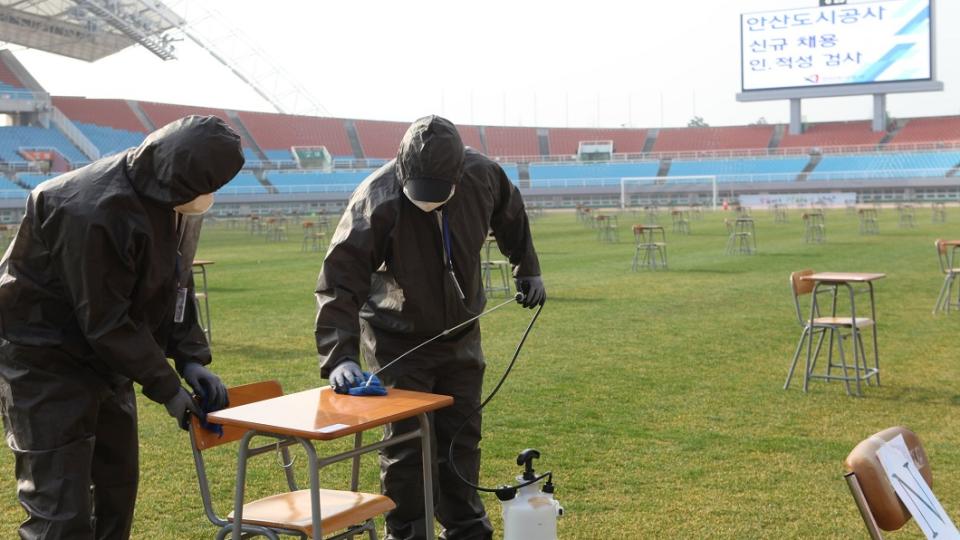 考試場地除了空曠，彼此座位還相隔5公尺，現場更是有防疫人員忙著消毒。(圖／翻攝自推特)