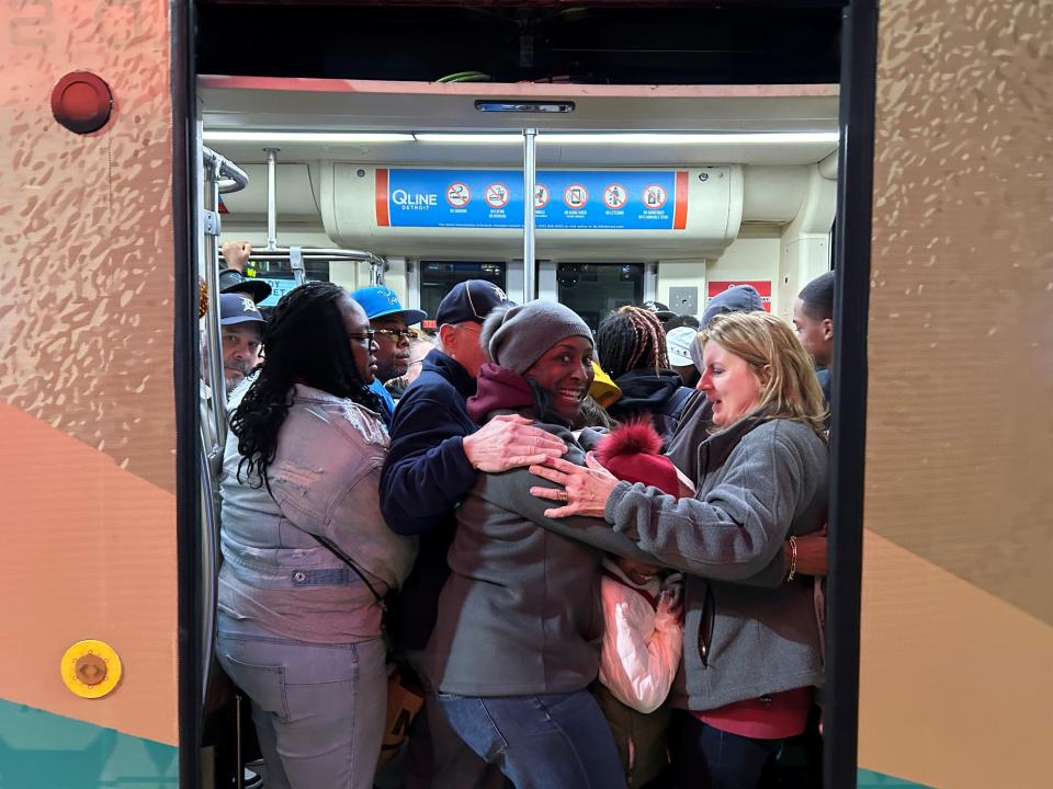 People squeeze onto the northbound QLINE at Woodward and Canfield Friday night during the second day of the NFL draft.