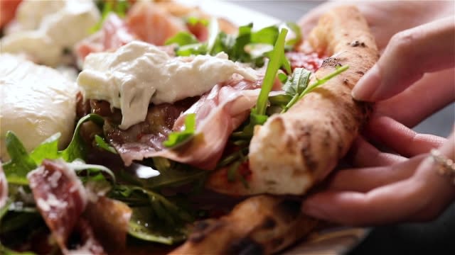 parma burrata pizza slice with freshly spread burrata cheese