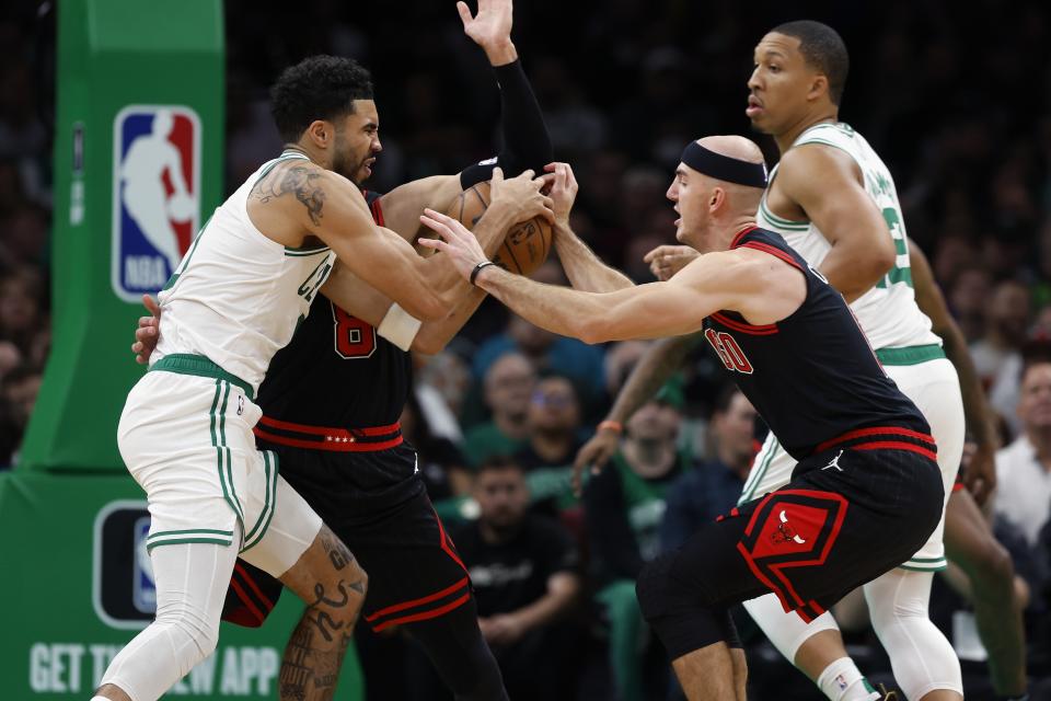 Boston Celtics' Jayson Tatum, left, battles Chicago Bulls' Zach LaVine (8) and Alex Caruso, front right, for the ball during the first half of an NBA basketball game, Friday, Nov 4, 2022, in Boston. (AP Photo/Michael Dwyer)