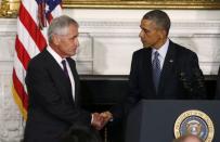 U.S. President Barack Obama (R) greets Defense Secretary Chuck Hagel after announcing Hagel's resignation at the White House in Washington, November 24, 2014. REUTERS/Larry Downing