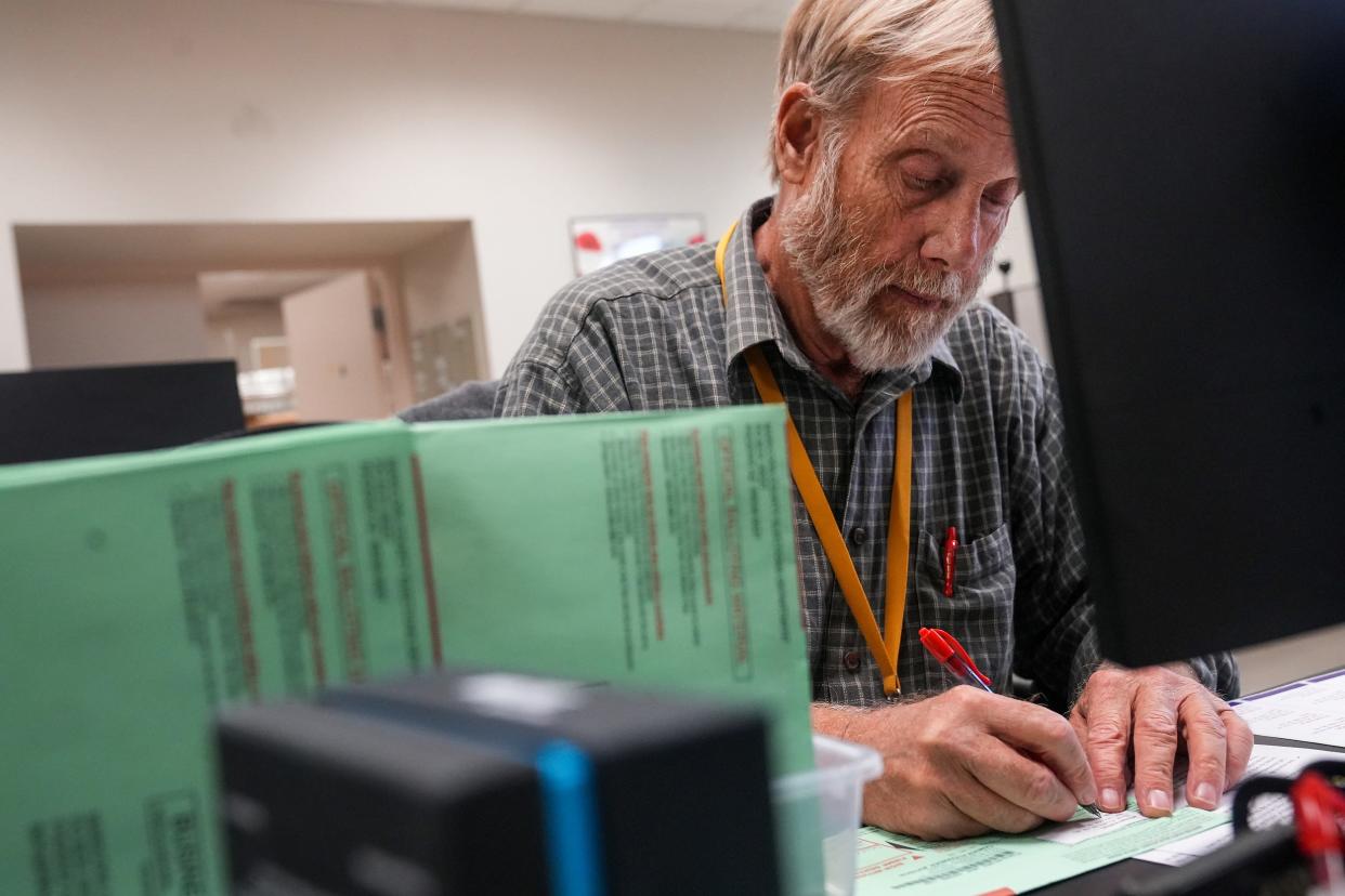 An election worker makes calls to voters to cure their signatures so their ballots will count at the Maricopa County Tabulation and Election Center in Phoenix on Nov. 13, 2022. Maricopa County is home to more than half the state’s voters. Most Arizona voters cast ballots by mail.