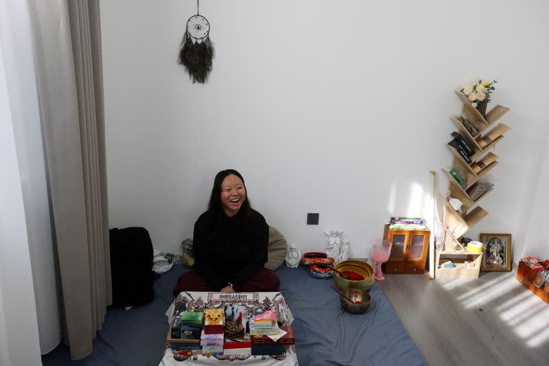 Bai Yunxi, 33, a full-time astrologer, laughs during an interview with Reuters in Dali