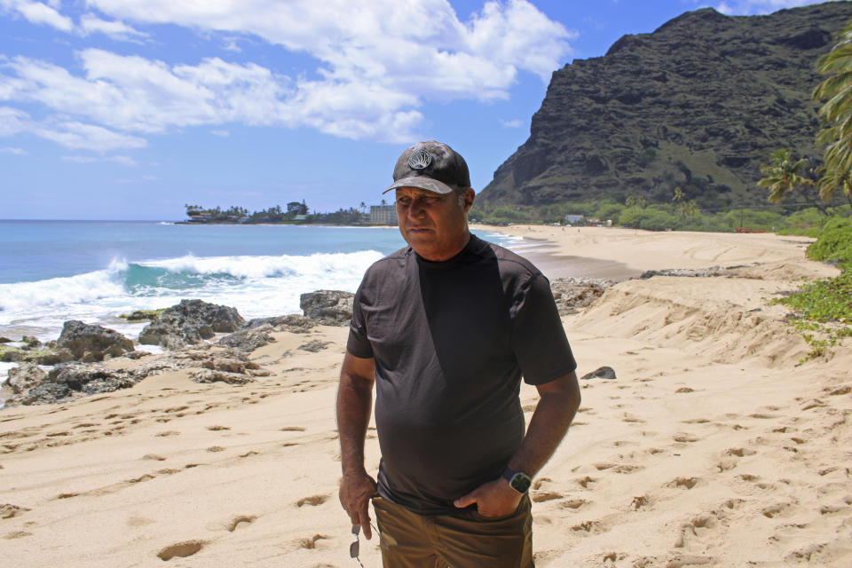 Brian Keaulana stands on Makaha beach in Waianae, Hawaii on Tuesday, May 9, 2023. The prominent Native Hawaiian waterman wants to build another surf park in Hawaii, but opponents say it's a waste of water and pointless in Hawaii, the birthplace of surfing, where a good break is often just minutes away. (AP Photo/Jennifer Sinco Kelleher)