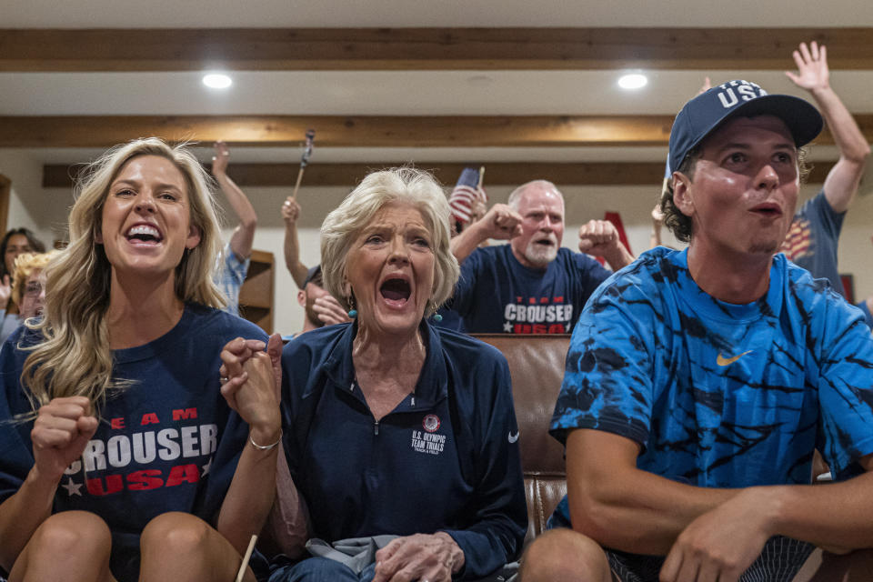 Cousin Haley Crouser, left, grandmother Marie Crouser, center, and brother Matt Crouser, right, watch with other friends and family as Ryan Crouser wins the gold medal at the shot put finals at the Tokyo Olympics, Wednesday, Aug. 4, 2021, in Redmond, Ore. (AP Photo/Nathan Howard)