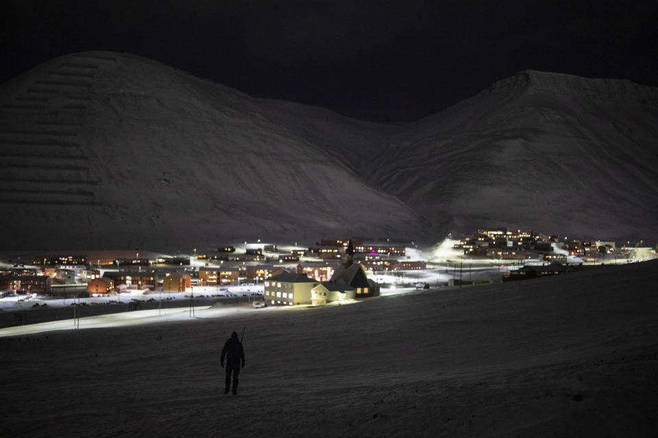 Svalbard Kirke member Lars-Olav Tunheim descends from Plataberget mountain during a hike in Longyearbyen, Norway, Wednesday, Jan. 11, 2023. As climate change impacts the Svalbard archipelago faster and deeper than the rest of the world, its pastor is helping the community of miners and environmentalists grapple with transformation in this unforgiving, awe-inspiring wilderness. (AP Photo/Daniel Cole)