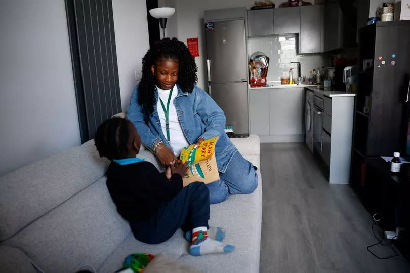 Dorcas reading to her son in her Grand Heights flat