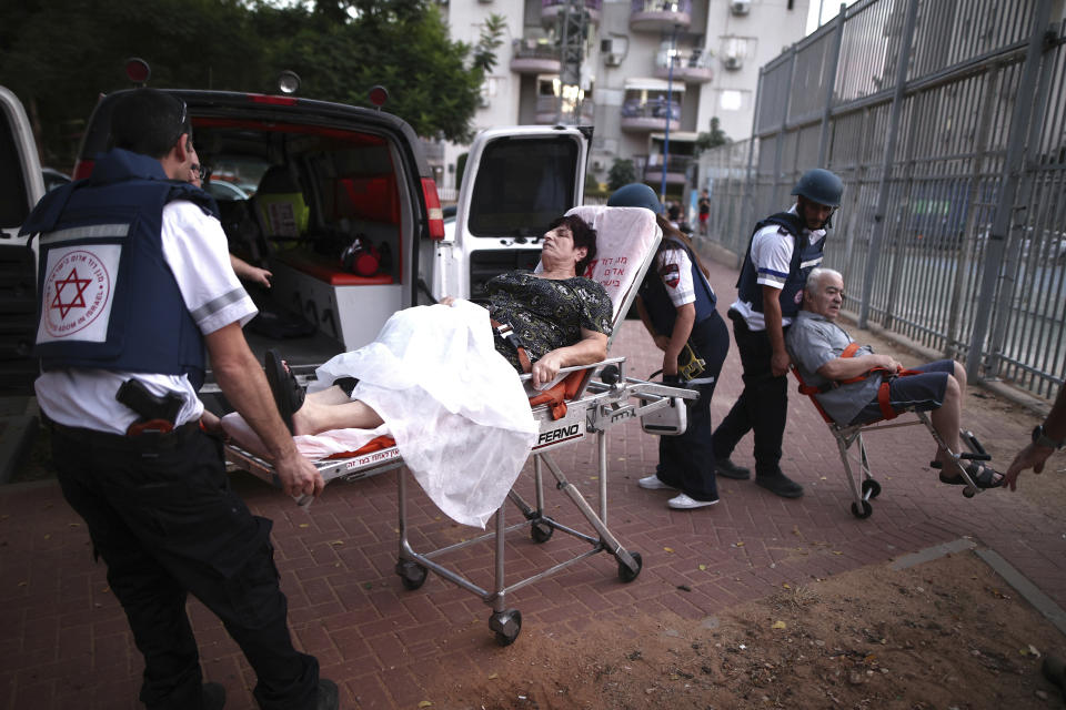 Paramedics evacuate wounded Israelis from a building after its parking lot was hit by a rocket fired from the Gaza Strip, in Ashdod, southern Israel, Tuesday, Oct. 31, 2023. (AP Photo/Ilan Assayag)