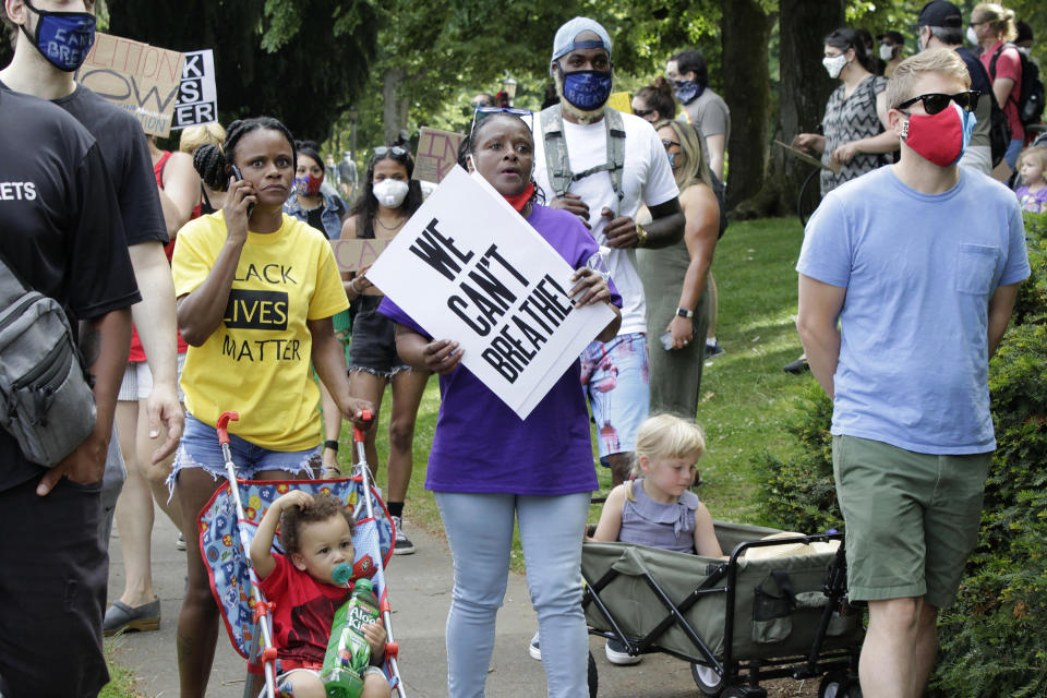 Katrina Hendricks, left, pushes a stroller holding her son, Melo, as her mother, Elaine Loving, walks alongside her at a Juneteenth rally and march through a historically Black neighborhood in Portland, Ore., Friday, June 19, 2020. Loving has lived in the same house in the North Portland neighborhood since her birth in 1959, but says many Black families have moved away as white gentrification has occurred. She appreciates seeing so many white people at the rallies and protests but would like to see more true investment in her community from recently arrived white families. Juneteenth marks the day in 1865 when federal troops arrived in Galveston, Texas, to take control of the state and ensure all enslaved people be freed, more than two years after the Emancipation Proclamation. (AP Photo/Gillian Flaccus)