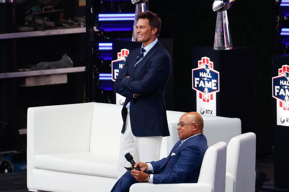 <p>China Wong/Getty</p> Tom Brady and Mike Tirico look on during the 2024 Hall of Fame Induction Ceremony for Tom Brady