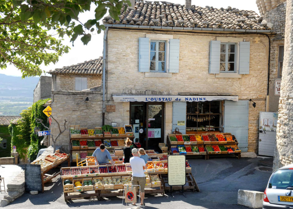 <div class="inline-image__caption"><p>"A classic village fruit and vegetable store with customers in Gordes.</p></div> <div class="inline-image__credit">Getty Images</div>