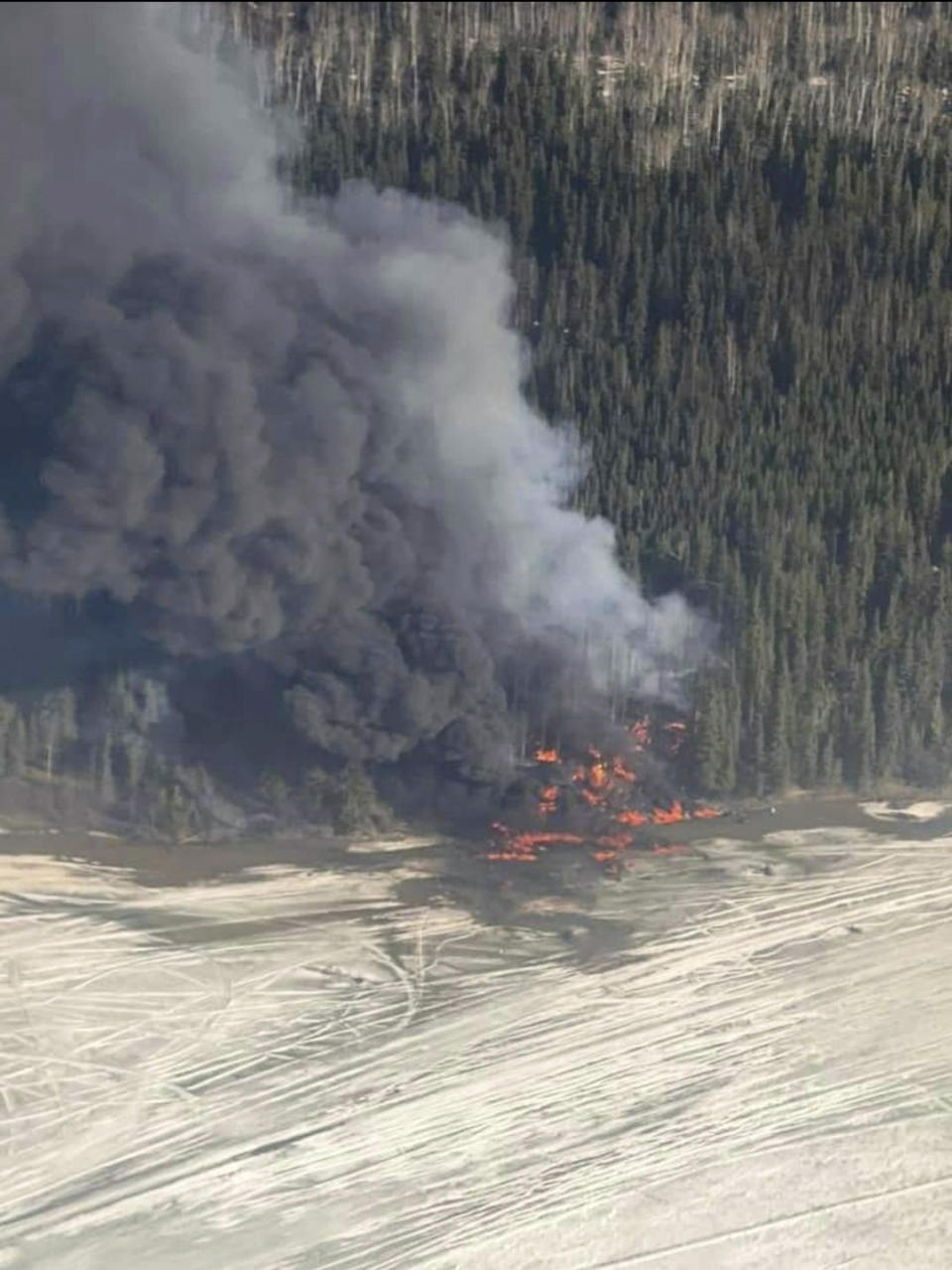 A fire burns after a Douglas C-54 Skymaster plane crashed into the Tanana River outside Fairbanks, Alaska, Tuesday, April 23, 2024. (Michaela Matherne via AP)