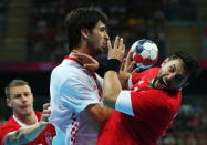 LONDON, ENGLAND - AUGUST 12: Marko Kopljar (center) #8 of Croatia and Attila Vadkerti #24 of Hungary collide during the Men's Handball Bronze Medal Match on Day 16 of the London 2012 Olympic Games at Basketball Arena on August 12, 2012 in London, England. (Photo by Jeff Gross/Getty Images)