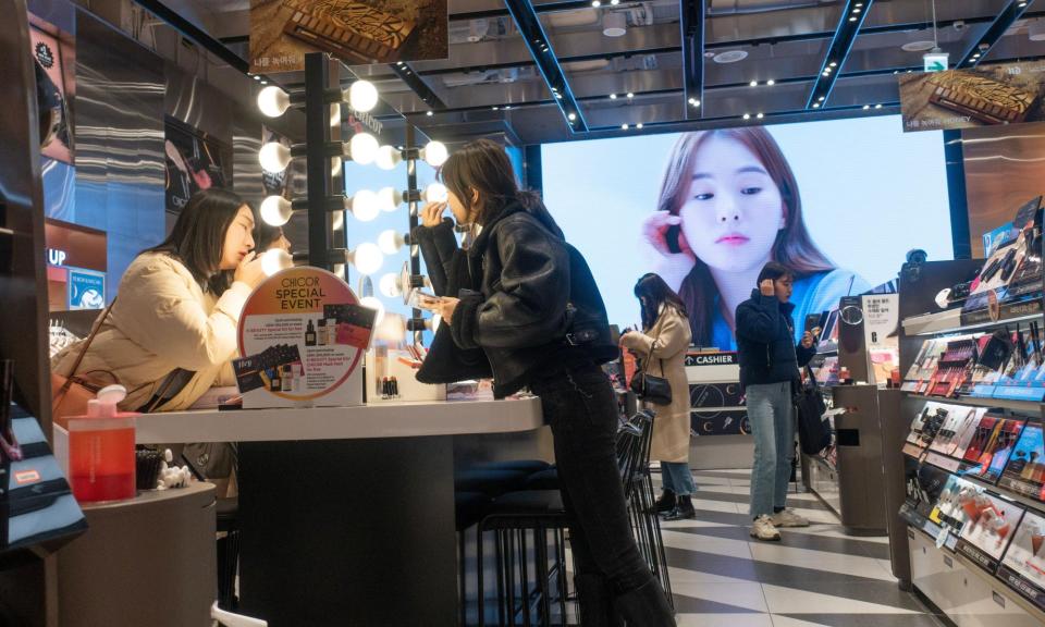 <span>Women try beauty products in a store in Seoul. Brands such as Cosrx, Beauty of Joseon and Laneige are becoming increasingly popular in the UK.</span><span>Photograph: Carlo Bollo/Alamy</span>