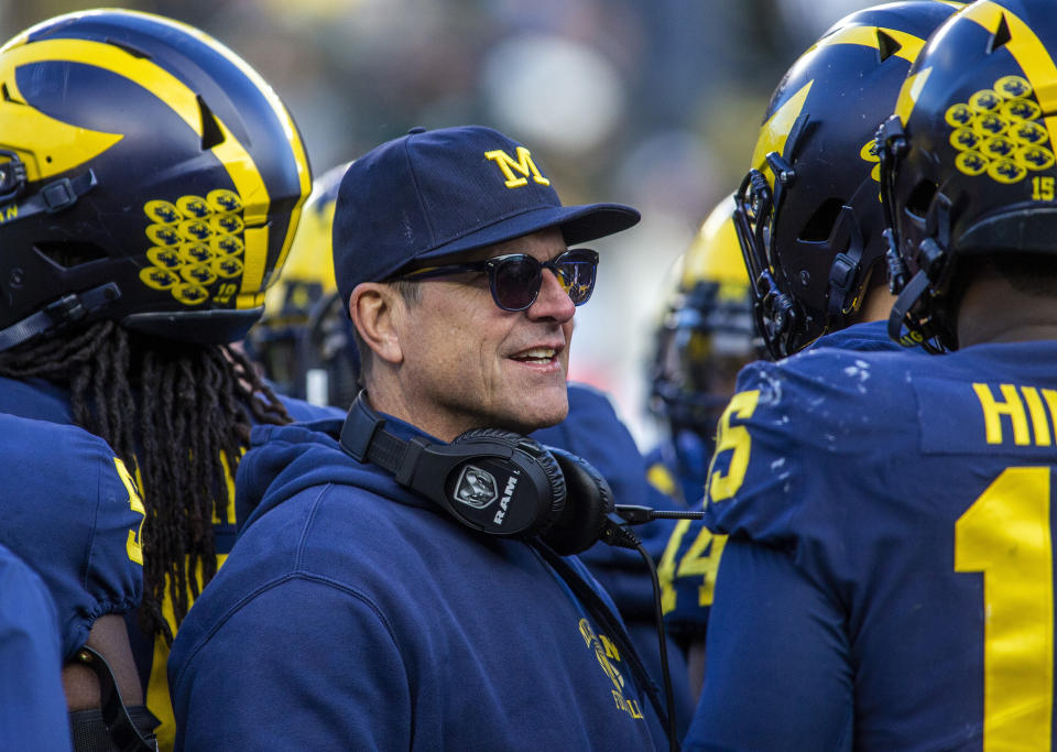 FILE - In this Nov. 16, 2019, file photo, Michigan head coach Jim Harbaugh huddles with his players on the field during a time out in the fourth quarter of an NCAA college football game against Michigan State in Ann Arbor, Mich. Jim Harbaugh enters his sixth season as Michigan's coach with just two years left on his contract, adding another layer of interest in the 18th-ranked Wolverines as they kick off the season this week at No. 21 Minnesota. (AP Photo/Tony Ding, File)