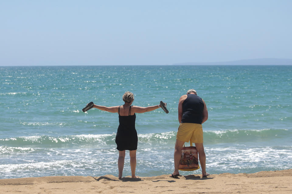 German tourists arrive at the beach of Palma de Mallorca, Spain, Monday, June 15, 2020. Borders opened up across Europe on Monday after three months of coronavirus closures that began chaotically in March. But many restrictions persist, it's unclear how keen Europeans will be to travel this summer and the continent is still closed to Americans, Asians and other international tourists. (AP Photo/Joan Mateu)