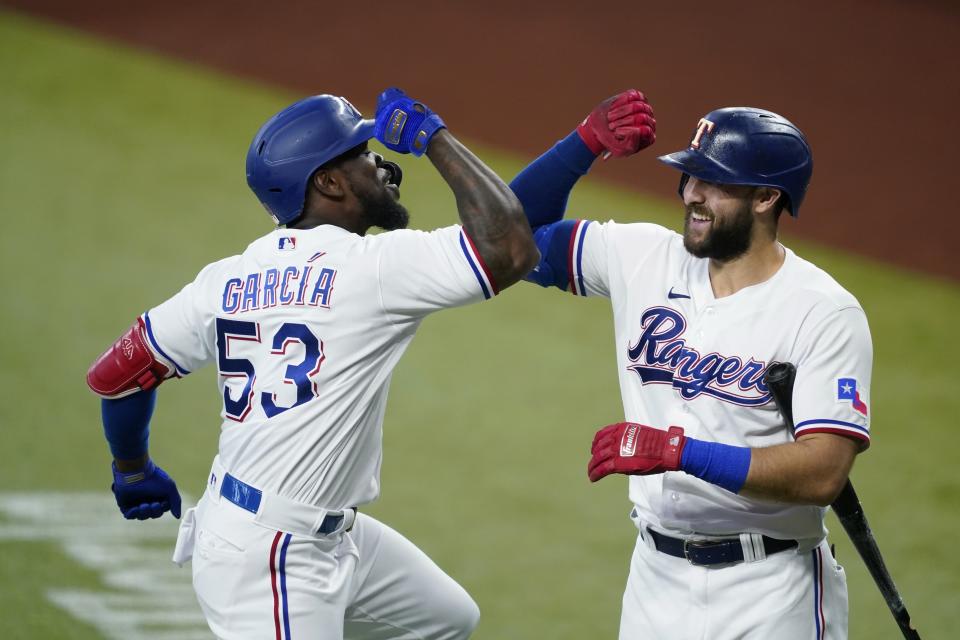 Texas Rangers' Adolis Garcia (53) and Joey Gallo, right, celebrate Garcia's solo home run in the first inning of a baseball game against the Oakland Athletics in Arlington, Texas, Saturday, July 10, 2021. (AP Photo/Tony Gutierrez)