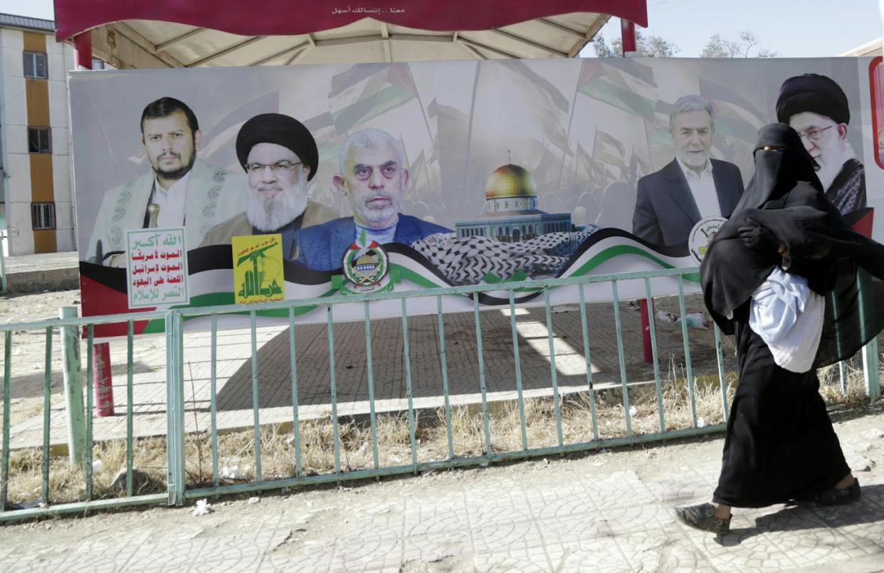 A billboard depicts the leaders of the Houthis, Hezbollah, Hamas, Islamic Jihad and Iran's Ayatollah Ali Khamenei. <a href="https://www.gettyimages.com/detail/news-photo/yemeni-woman-carrying-her-bay-walks-near-a-billboard-with-news-photo/1942966164?adppopup=true" rel="nofollow noopener" target="_blank" data-ylk="slk:Mohammed Hamoud/Getty Images;elm:context_link;itc:0;sec:content-canvas" class="link ">Mohammed Hamoud/Getty Images</a>