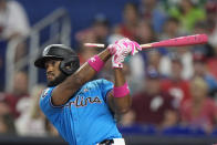 Pieces of bat fly off of Miami Marlins' Bryan De La Cruz as he bats during the first inning of a baseball game against the Philadelphia Phillies, Sunday, May 12, 2024, in Miami. (AP Photo/Wilfredo Lee)