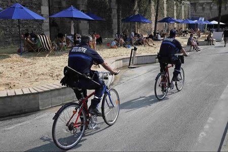 French municipal police on bicycles patrol along the banks of the Seine during the "Paris plage" event in Paris, France, August 12, 2015. REUTERS/Pascal Rossignol