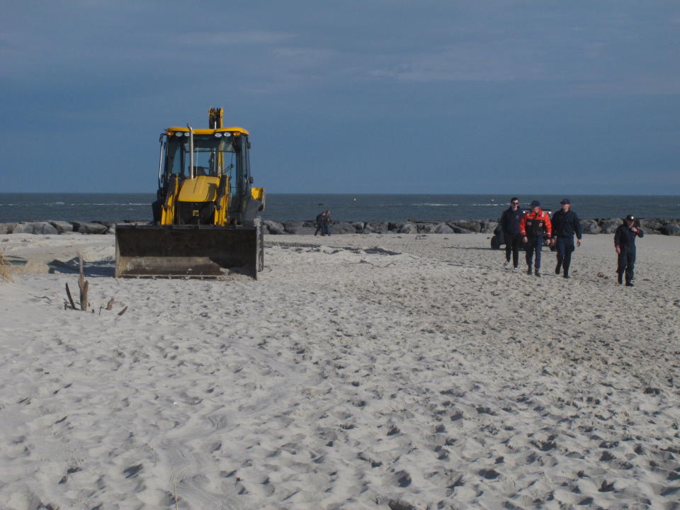 A front-end loader rests on the sand in Barnegat Light N.J. on Monday, Dec. 28, 2020, after burying a 15-ton humpback whale whose carcass had washed ashore three days earlier. (AP Photo/Wayne Parry)