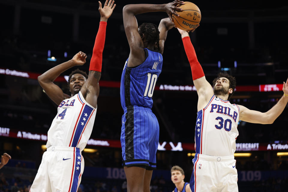 Philadelphia 76ers guard Furkan Korkmaz (30) blocks the shot of Orlando Magic center Bol Bol as 76ers forward Paul Reed defends during the second half of an NBA basketball game Sunday, Nov. 27, 2022, in Orlando, Fla. (AP Photo/Scott Audette)