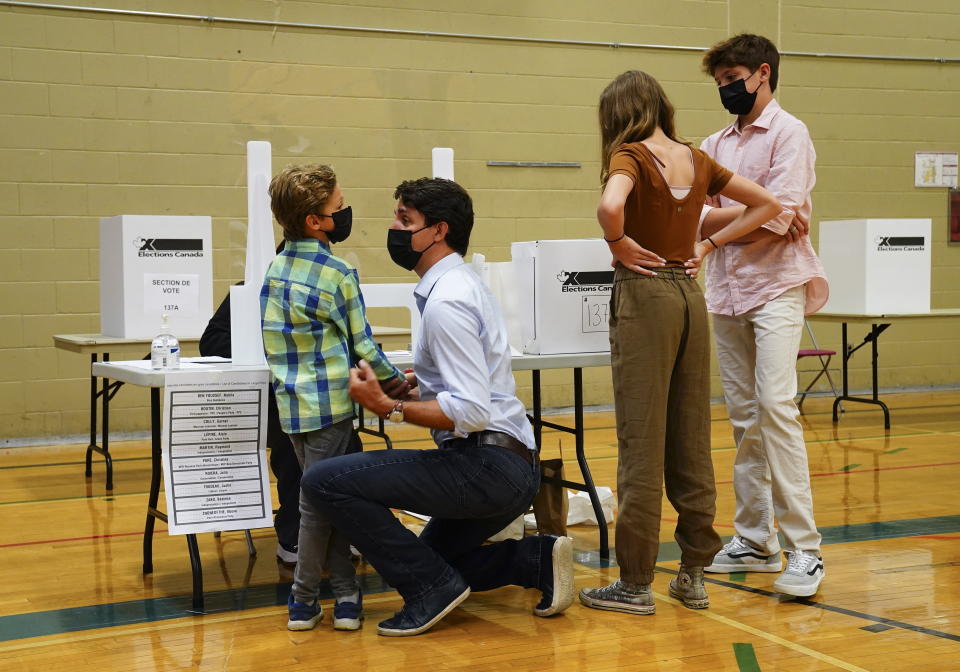 Liberal leader Justin Trudeau votes with the help of his children, left to right, Hadrien, Ella-Grace and Xavier, in Montreal, Quebec on Monday, Sept. 20, 2021. Canadians are voting in a pandemic election that threatens to knock Prime Minister Justin Trudeau from power. Trudeau gambled on an early election Monday in a bid to win a majority of seats in Parliament. (Sean Kilpatrick/The Canadian Press via AP)